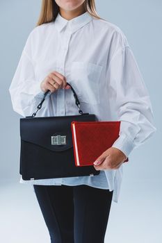 Black classic leather bag in a girl's hand. Woman with luxury bag.