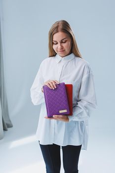 A stylish woman holds a notebook in her hands. Notebook for business records.