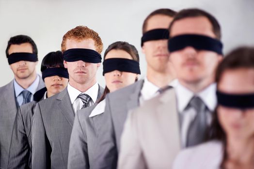 None as blind as those who will not see. a group of businesspeople all wearing blinfolds