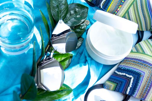 A glass glass of water on a blue background and a green plant with large leaves.,,