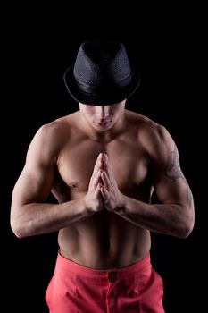 Portrait of muscular dancer in hat in dark
