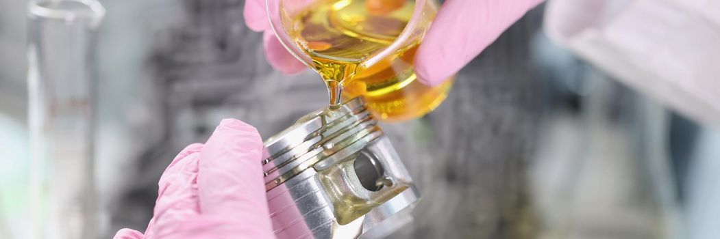 Close-up of mans hand in rubber gloves holding car part and pours lubricating oil on it. Mechanic fix component of vehicle. Lab, pit stop, handyman concept