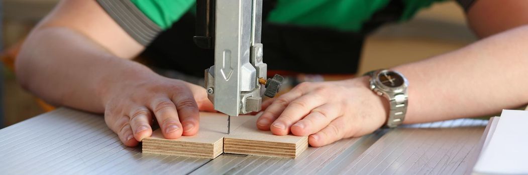 Portrait of worker using electric saw, handyman on workplace, diy. Improvement, startup idea, industrial building. Carpentry, renovation, design concept