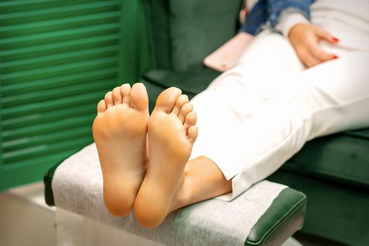 Feet of a young caucasian woman while treatment procedure in a beauty salon