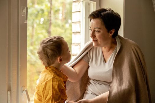 Happy grandmother and grandson enjoy time together. Positive middle age woman spending time with little, cute grandchild. 50-year-old grandma with grandkid. Multi-generational family