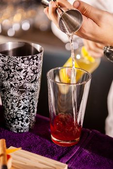 Closeup of bartender hands pouring alcoholic drink.Professional drink making