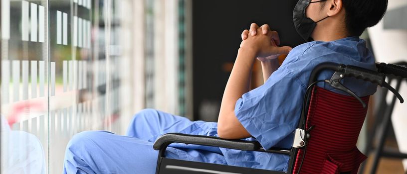 Man patient sitting on wheelchair in hospital room feeling lonely and depress.