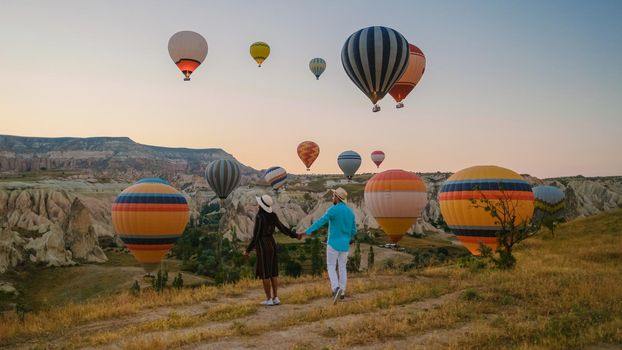 Kapadokya Cappadocia Turkey, a happy young couple during sunrise watching the hot air balloons of Kapadokya Cappadocia Turkey during vacation