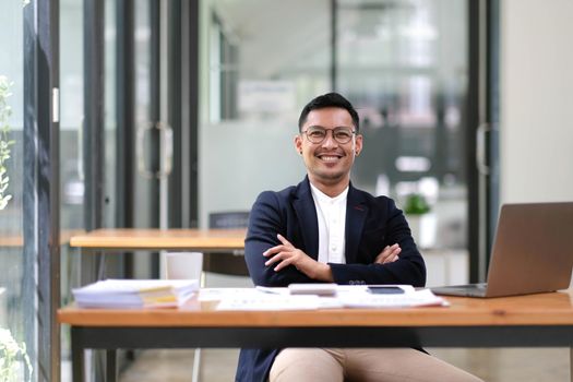 Portrait of successful handsome executive businessman smart looking at camera and smiling, happy in modern office workplace..