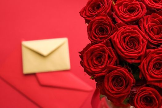 Holiday gift, flowers flatlay and happy relationship concept - Love letter and flower delivery service on Valentines Day, luxury bouquet of red roses and card envelopes on red background