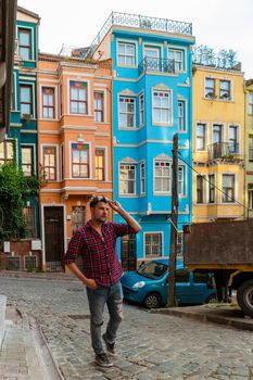 Young men tourists in Balat district Istanbul Turkey, colorful homes and houses in the town of Balat with tourists enjoying a beautiful summer day.