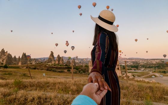 Kapadokya Cappadocia Turkey, a happy young couple during sunrise watching the hot air balloons of Kapadokya Cappadocia Turkey during vacation