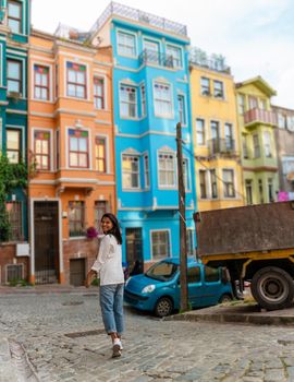 Asian women on city trip Balat district Istanbul Turkey, colorful homes and houses in the town of Balat with tourists enjoying a beautiful summer day.