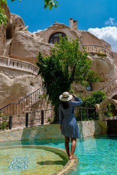 woman in dress at cave house, woman infinity pool cave house hotel in the mountains of Cappadocia.