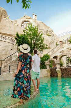 men and woman in dress at cave house, woman infinity pool cave house hotel in the mountains of Cappadocia.