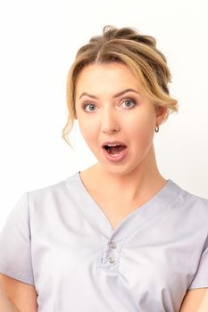 Young surprised Caucasian woman doctor having shocked expression opening her mouth against the white background