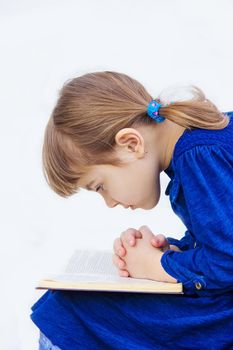 The child prays to God. Selective focus.