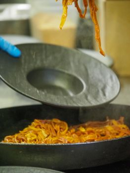closeup of a chef hand wearing gloves serving and decorating a plate of pasta