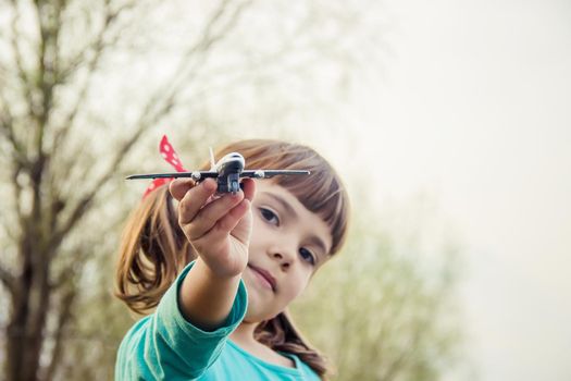 The plane is in the hands of the child. Selective focus.