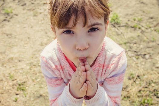 The child prays to God. Selective focus.