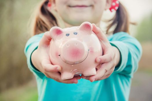 piggy bank in the hands of a child. saving. selective focus.