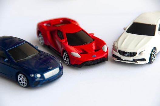 Kuala Lumpur, Malaysia - September 2022 : Miniature toy car of Bentley Continental GT, Ford GT and Mercedes AMG with gold on white background. Copy space
