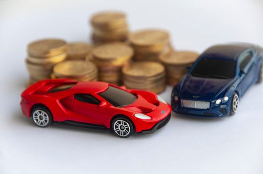 Kuala Lumpur, Malaysia - September 2022 : Miniature toy car of Ford Gt and Bentley Continental GT with gold coin background. Copy space.