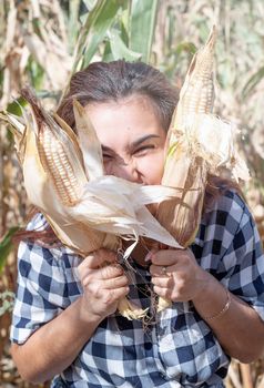 agriculture and cultivation concept. Countryside.portrait of funny female woman in corn crop holding cobs making funny faces