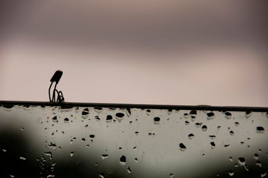 Lonely safety pin sitting on glass wall with customizable space for text and ideas. Lonely concept.