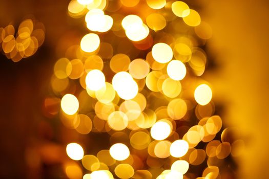 Warm golden festive christmas garland lights blurred background.