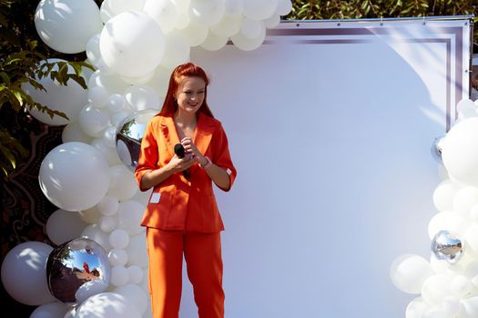 person who writes for newspapers, magazines, or news websites or prepares news to be broadcast. presenter, karaoke host. Young pretty woman event presenter in an orange pantsuit with microphone.