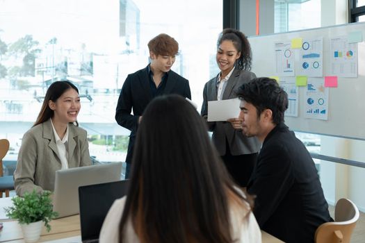 Group of diverse colleagues discussing for financial report with presentation on flipchart during a small conference in the office.