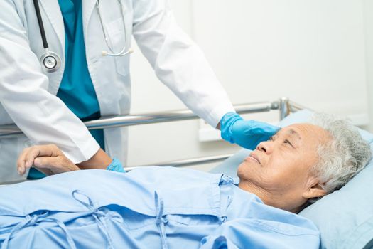 Doctor checking senior or elderly old lady woman patient lie down in nursing hospital ward, healthy strong medical concept.