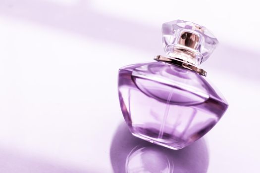 Perfumery, spa and branding concept - Purple perfume bottle on glossy background, sweet floral scent, glamour fragrance and eau de parfum as holiday gift and luxury beauty cosmetics brand design