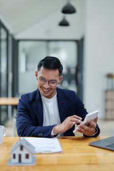 Guarantee, mortgage, contract, contract, signed,A portrait of a man showing a smiling face while using the housing price calculator to assess real estate investment risk.