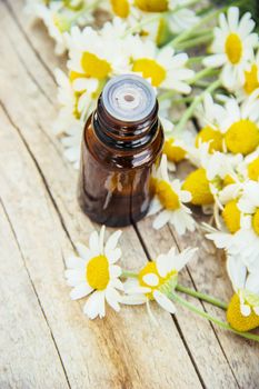 Chamomile extract in a small bottle. Selective focus nature.