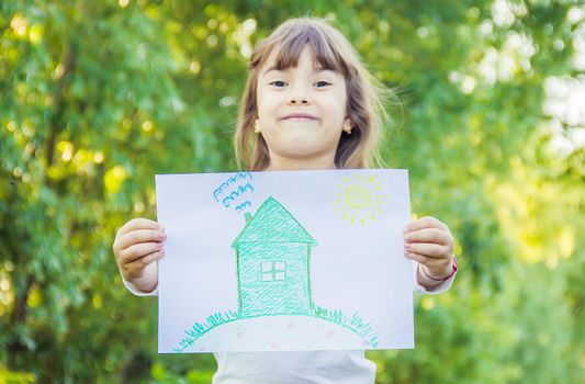 Drawing of a green house in the hands of a child.