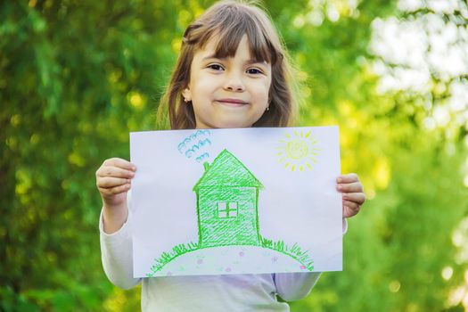 Drawing of a green house in the hands of a child.