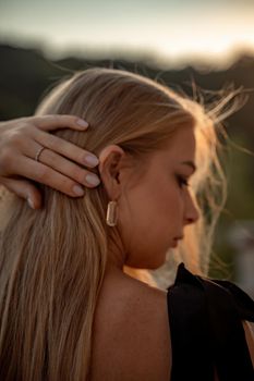 Blonde long hair, nature summer happy adult girl with long blond hair developing in the wind in nature. Dressed in a black top, white skirt