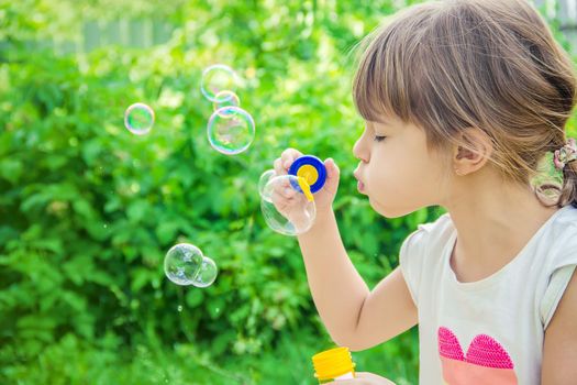 The children are blowing bubbles. Selective focus.