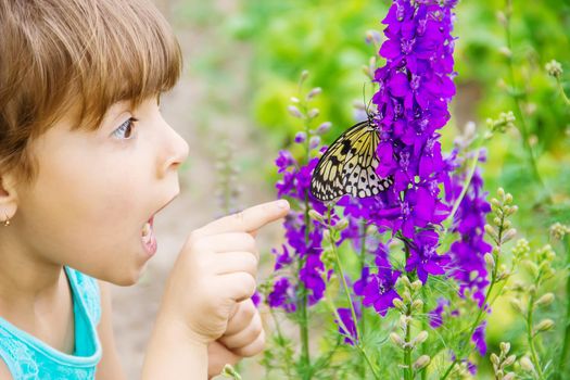 Child with a butterfly. Idea leuconoe. Selective focus.