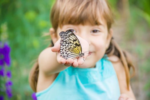 Child with a butterfly. Idea leuconoe. Selective focus.