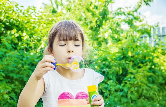 The children are blowing bubbles. Selective focus.