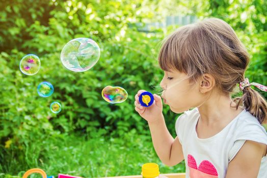 The children are blowing bubbles. Selective focus.