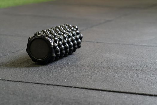 Black foam roller athletic massage exercise sport body workout, from healthy indoor in activity and shape equipment, caucasian movement. Rolling ,