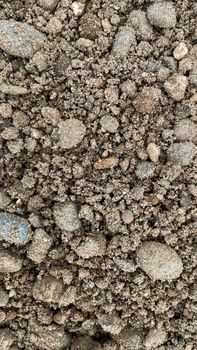 Gray fine stone texture of the soil. small black background made of road stone. road pebbles with a stone texture. dark background of crushed granite gravel.