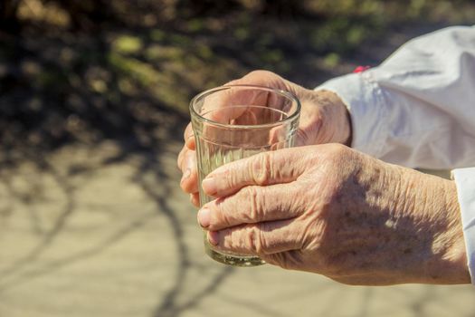 Grandmother giving a glass of clean water to a child. Selective focus.