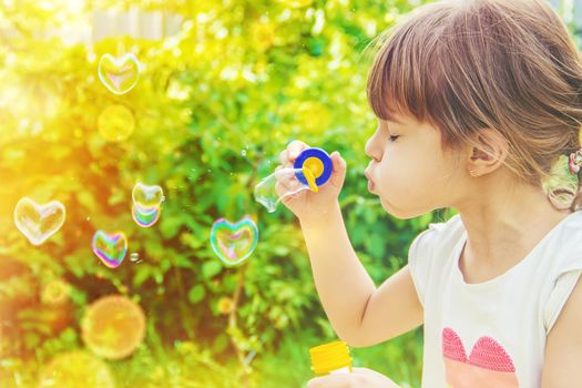 The children are blowing bubbles. Selective focus.