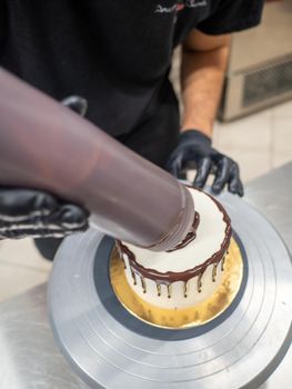 decorating a frosted cake with chocolate and nutella