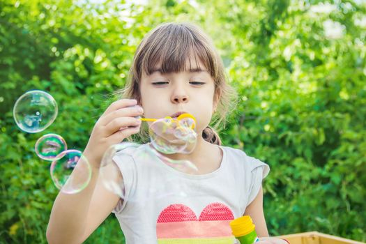 The children are blowing bubbles. Selective focus.